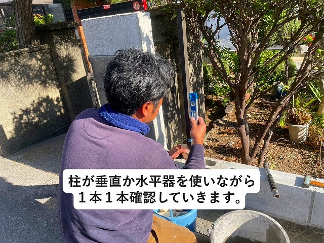 加古郡稲美町にてアルミ製フェンスの柱を垂直に設置している様子